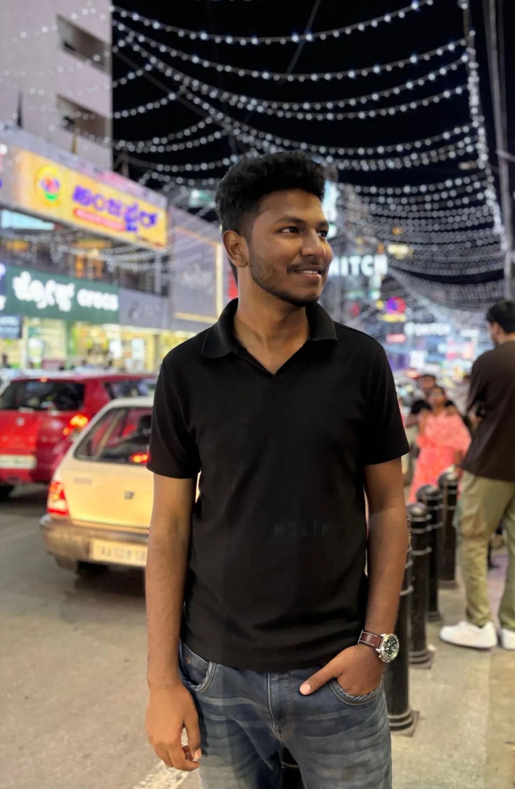 On a street at night under string lights
