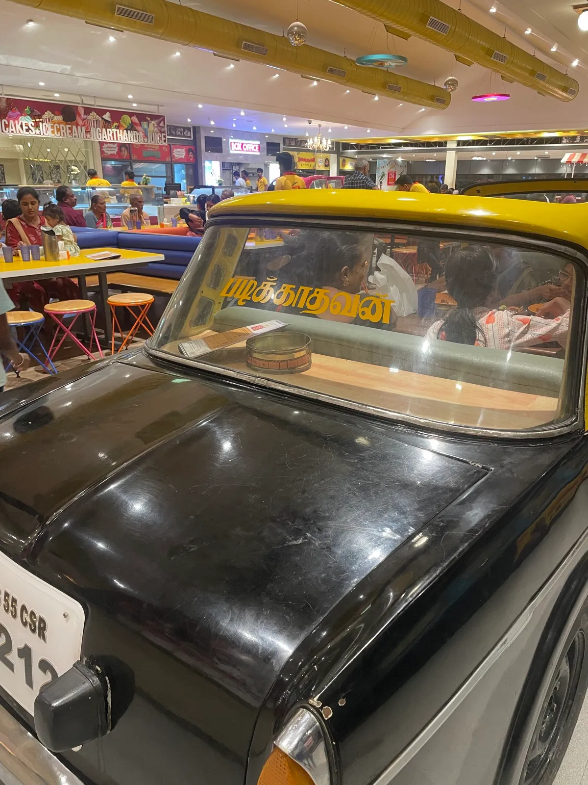 A vintage black-and-yellow taxi on display