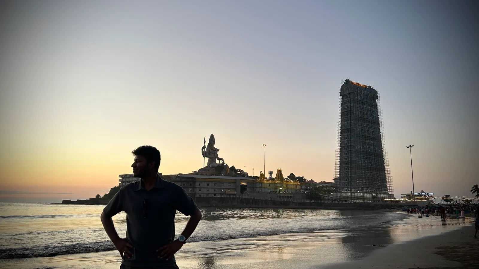 Silhouette on the beach at Kanyakumari with the Thiruvalluvar statue behind