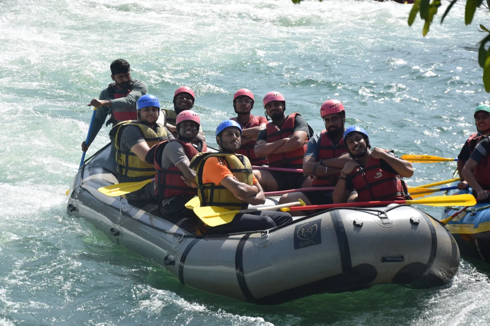 A raft full of people in helmets going through rapids